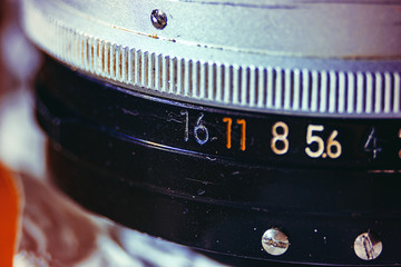 Old manual control lens body. Scratches and dirt. Close-up on the numbers of aperture ring. Concept...