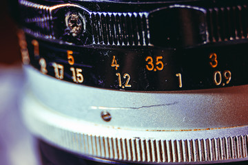 Old manual control lens body. Scratches and dirt. Close-up on the numbers of aperture ring. Concept of repair