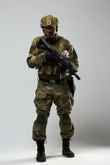 Full-length photo of military man in camouflage with gun