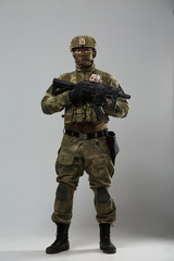 Full-length portrait of soldier in camouflage with gun