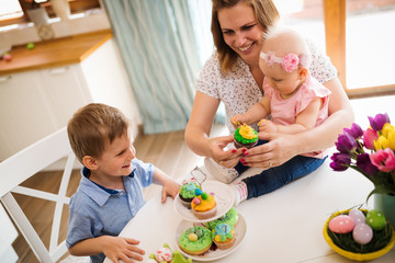 Happy easter. A mother and her kids painting Easter eggs