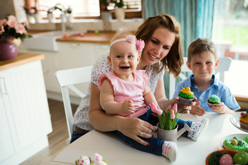 Happy and loving mother and her kids preparing home decoration