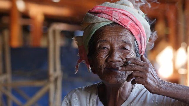 Old lady of Pa'O ethnic minority smoking a Burmese cigar at Indein village near Inle Lake, Shan State, Myanmar (Burma).