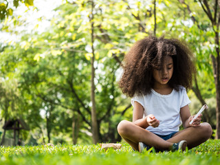 Beautiful girl sitting on green grass in a park