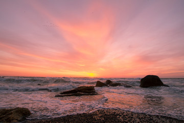 beautiful sea landscape in sunrise time, colorful pink and orange sky and storm in the sea.