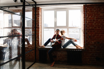 stylish young couple having fun in cozy bedroom in style loft,  feeling happy being together. The...