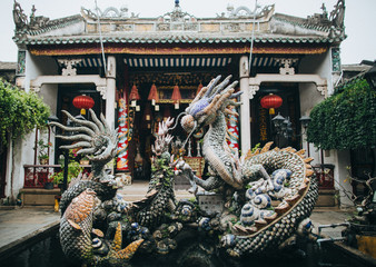 traditional oriental statues and architecture with red lanterns in Hoi An, Vietnam