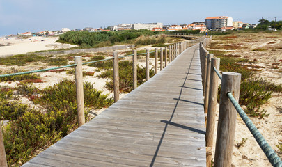 Fototapeta na wymiar Wooden promenade at sandy beach.