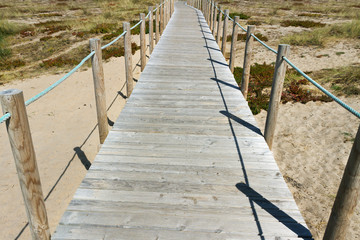 Wooden promenade at sandy beach.