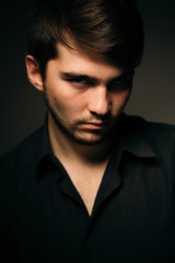 Fototapeta premium young brunette guy on a dark background