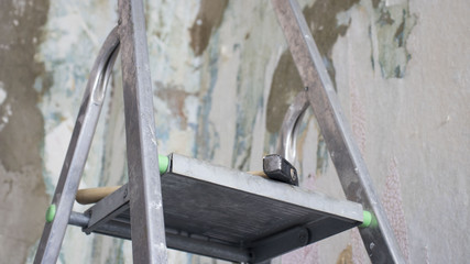 hammer on ladder on concrete wall background