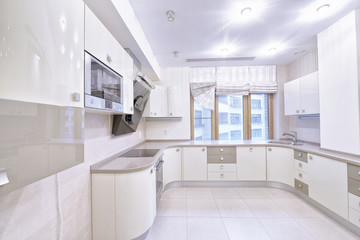 Fototapeta na wymiar Modern design white kitchen in a spacious apartment.