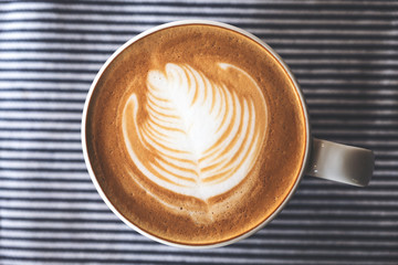Top view image of a cup of hot latte coffee with latte art