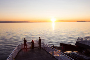 Naklejka na ściany i meble People on the ferry traveling from Vancouver to Vancouver Island, BC, Canada, are enjoying the beautiful summer sunset.