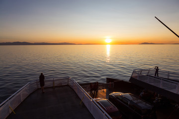 People on the ferry traveling from Vancouver to Vancouver Island, BC, Canada, are enjoying the beautiful summer sunset.