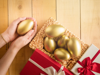 Financial success. Golden egg In a red gift box