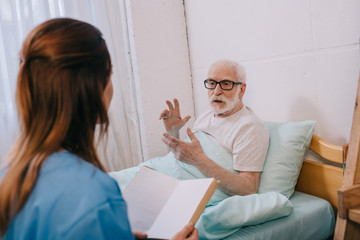 Old man patient and nurse discussing plot of the book