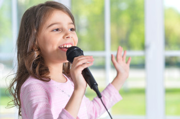 Beautiful little girl with microphone 