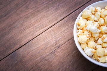 A bowl of popcorn on a wooden table