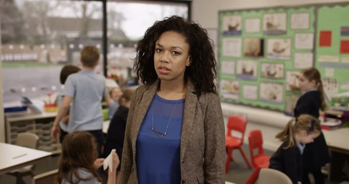 4k, Portrait of an unhappy class teacher while students wreak havoc in the background. Slow motion.