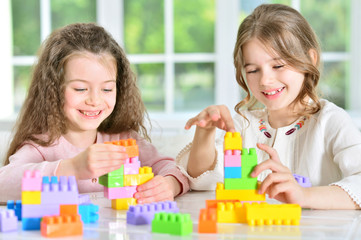 Obraz na płótnie Canvas little girls playing with plastic blocks