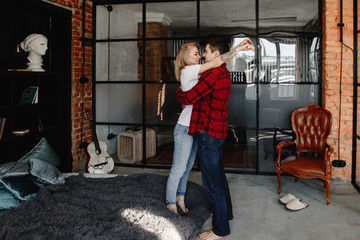 Fototapeta na wymiar stylish young couple having fun in cozy bedroom in style loft, feeling happy being together.