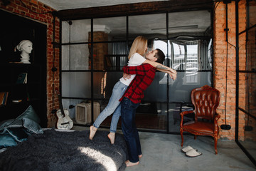 stylish young couple having fun in cozy bedroom in style loft,  feeling happy being together.