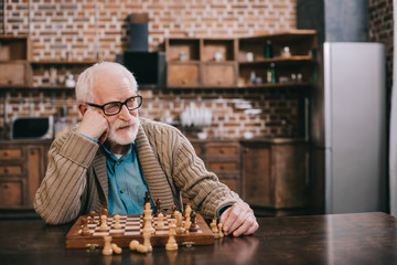 Bored senior man playing chess