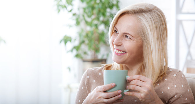 Portrait of happy blonde with mug in hands