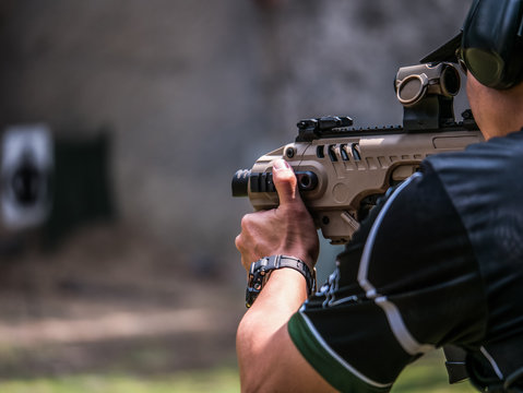 Male aim and shoot submachine gun to target in shooting competition