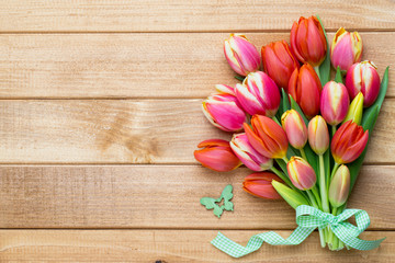 Spring easter tulips in bucket on wooden vintage background.