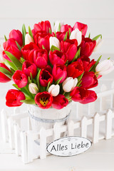 Springt time. Red tulip bouquet on the white wooden background.