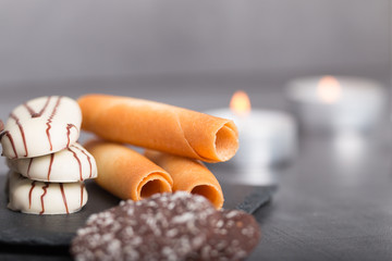 variety of biscuits on a table with coffee and flowers and candles