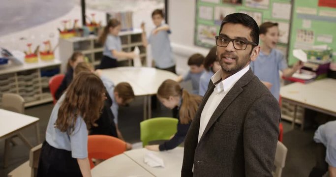 4k, Portrait of an unhappy class teacher while students wreak havoc in the background. Slow motion.