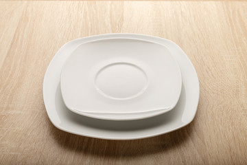 White plate on the table with the texture of oak ash tree.