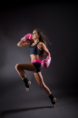 Fototapeta na wymiar dynamische frau bei fitnes mit boxhandschuhen
