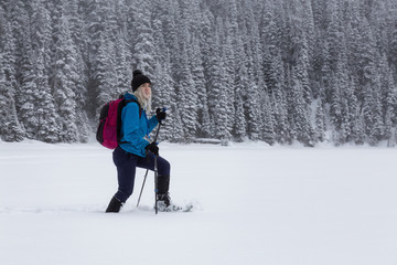 Adventurous girl snowshoeing in Joffre Lake, British Columbia, Canada.