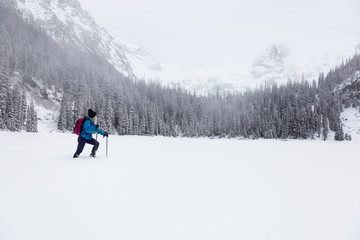 Adventurous girl snowshoeing in Joffre Lake, British Columbia, Canada.