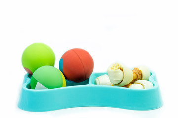 Pet accessories concept:  Bowl with snack and toys on isolated white.