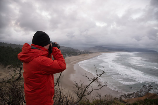 Photographer taking picture of the beautiful seascape on Pacific Ocean Coast. Taken in Cape Kiwanda, Oregon, America