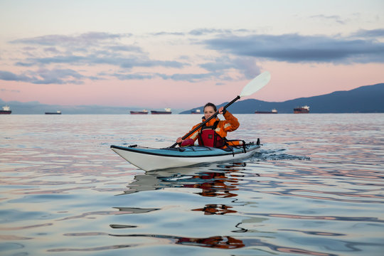 Sea Kayaking near Vancouver Downtown, British Columbia, Canada. Taken during a vibrant sunrise.