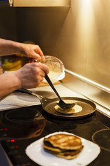 MAN COOKING PANCAKES ON COOKER RANGE