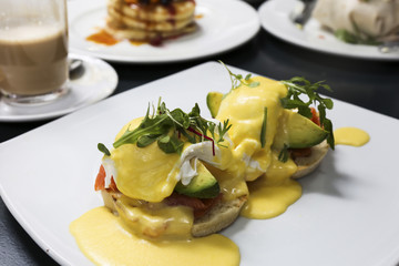 Healthy breakfast. Eggs Benedict with salmon and avocado on muffins.
