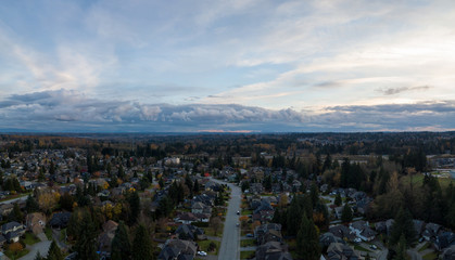 Aerial panoramic view of a suburban neighborhood during a vibrant and cloudy sunset. Taken in Greater Vancouver, British Columbia, Canada.