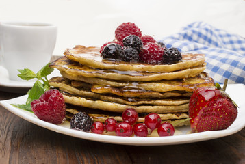 Delicious pancakes with berries and maple syrup. Top