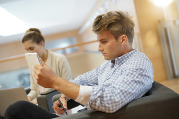 Students in lounge room connected with tablets