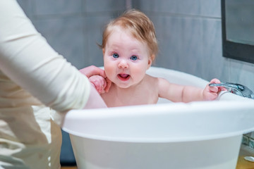 Funny baby bathing in the tub.