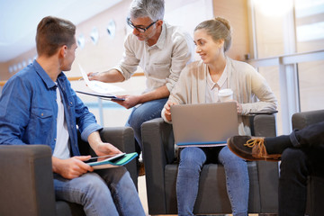 Obraz premium Group of students in lounge room with teacher