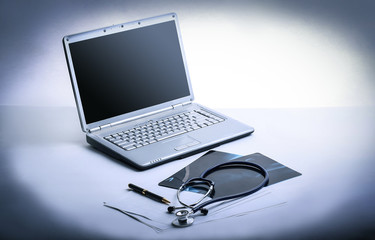 laptop ,stethoscope and x-ray on the table