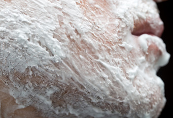 A man is applying face shaving foam